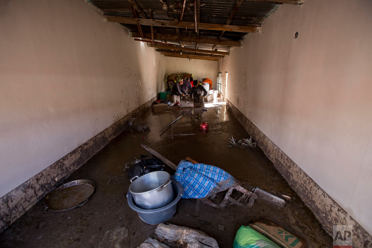 In this Jan. 13, 2017 photo, a resident begins the clean up of his mud flooded home in the town of Volcan, Jujuy province, Argentina. That town was covered by a mudslide a week ago after heavy rains hit the area. (Gianni Bulacio/Infoto via AP)