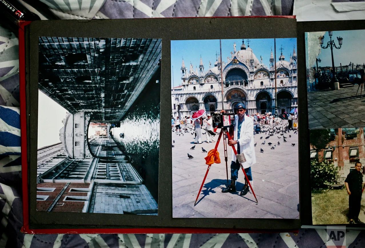 In this Dec. 20, 2016 photo, Luis Maldonado's photo album holds images of his trip to Venice, at his home in Santiago, Chile. He remains proud of the work he did at the 2003 Venice Biennale in an exhibit about traditional Chilean art forms by artist Eugenia Vargas, using his box camera to photograph people who lined up to have their portraits taken. (AP Photo/Esteban Felix)