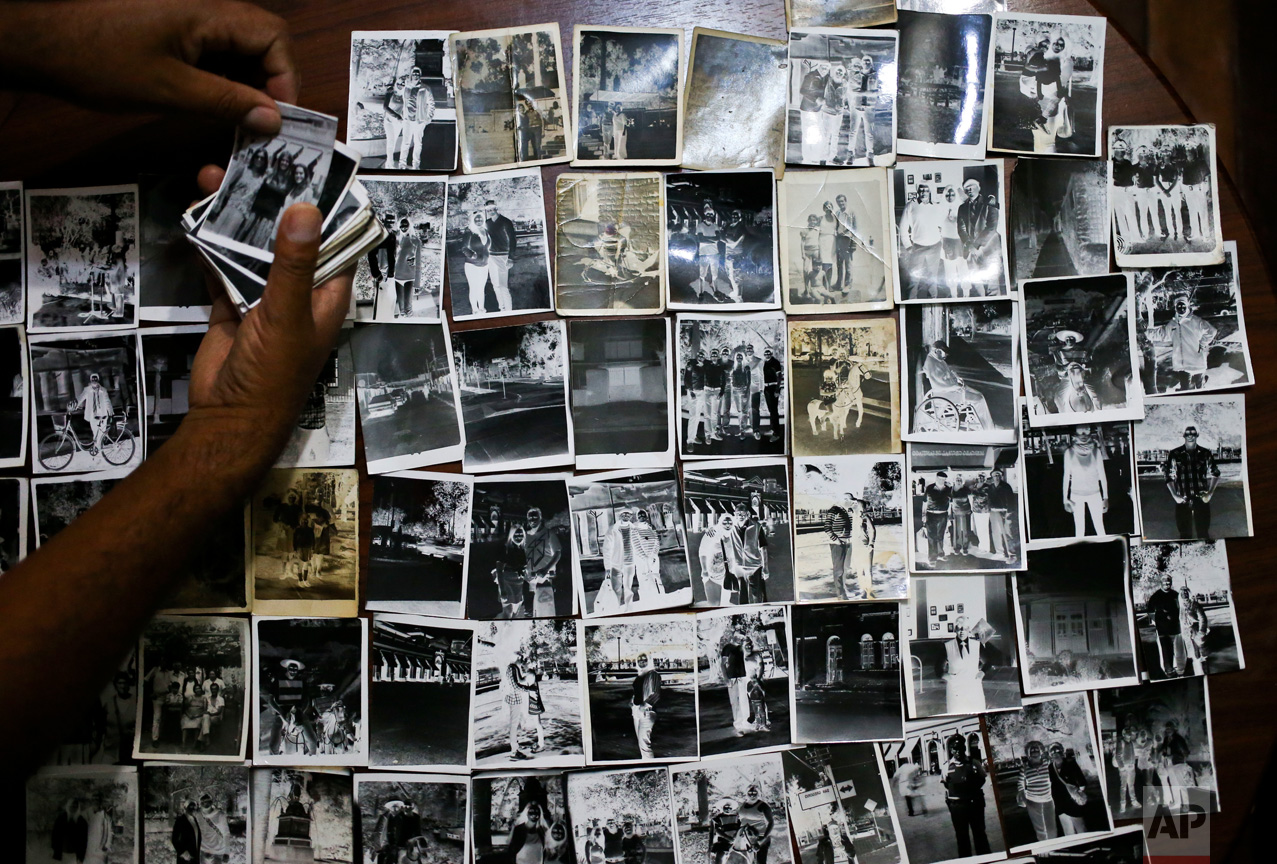 In this Dec. 20, 2016 photo, photographer Luis Maldonado shows negatives made by his grandfather, father or uncle, using this old wooden box camera, at his home in Santiago, Chile. The first wooden box camera arrived in Chile in 1911 and seven years later there were about 300 box photographers in the country, according to Chilean historian Octavio Cornejo. (AP Photo/Esteban Felix)