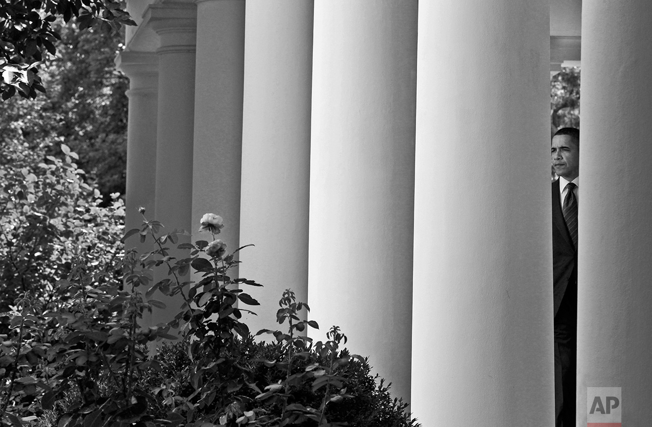 President Barack Obama is seen between the columns of the West Wing colonnade at the White House in Washington, Monday, July 26, 2010. (AP Photo/Charles Dharapak)