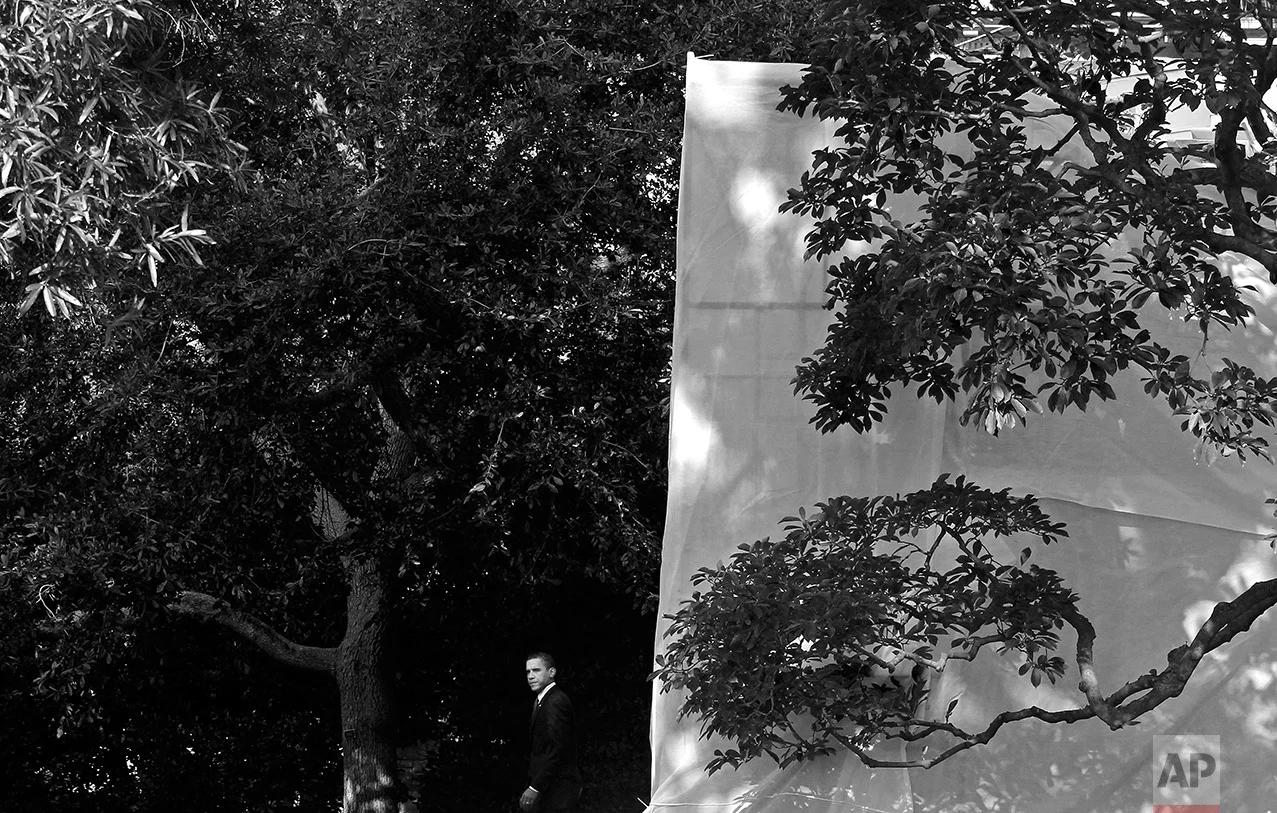 President Barack Obama walks from the Oval Office of the White House in Washington, Monday, Aug. 16, 2010, as the West Wing is covered in tarpaulin for a renovation project. (AP Photo/Charles Dharapak)