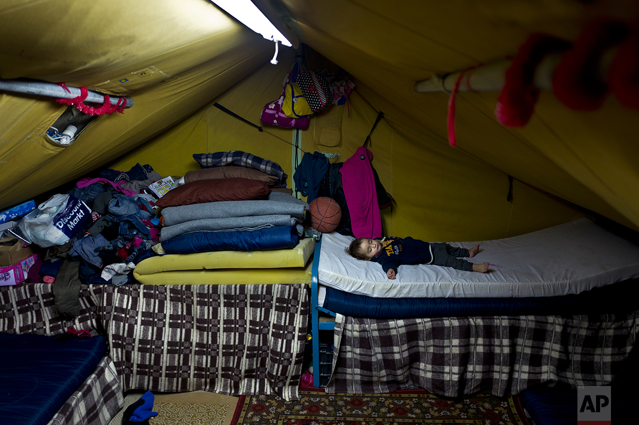 In this Thursday, Jan. 19, 2017 photo, Syrian refugee Elan Darwish, 14 months, sleeps inside his family's tent in Kalochori refugee camp on the outskirts of the northern Greek city of Thessaloniki. (AP Photo/Muhammed Muheisen)