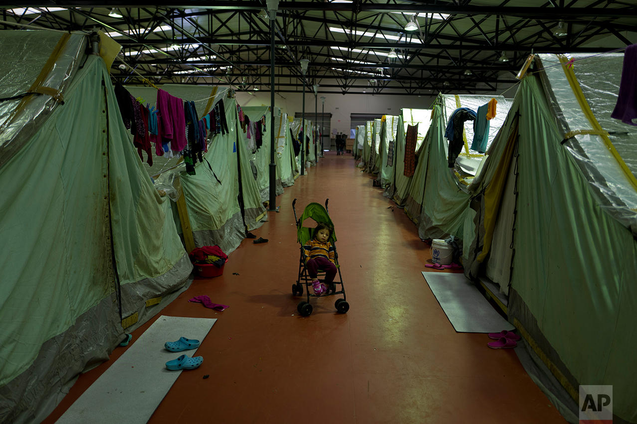 In this Thursday, Jan. 19, 2017 photo, a Syrian refugee child sits in a stroller outside his family's tent in Kalochori refugee camp on the outskirts of the northern Greek city of Thessaloniki. (AP Photo/Muhammed Muheisen)