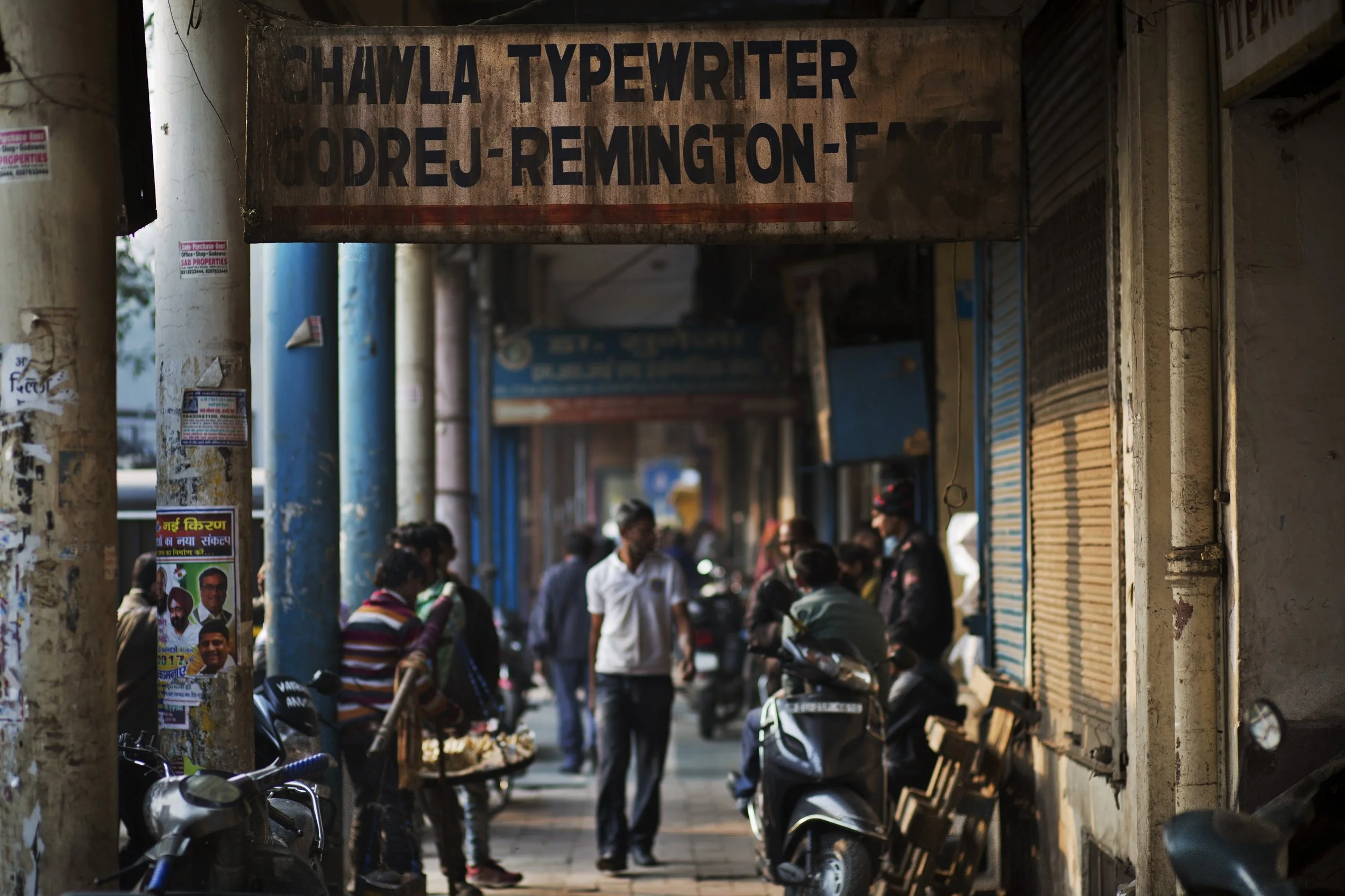 In this Jan. 16, 2017 photo, a rusted billboard of a typewriter shop hangs in an alley of New Delhi, India. The country still has a few thousand remaining professional typists. There are a handful of typewriter repairmen and stores selling spare parts. There are typing schools that, at least occasionally, are jammed with students. But even in this country, one of the last places in the world where the typewriter remains a part of everyday life, the end is, finally, coming. (AP Photo/Bernat Armangue)