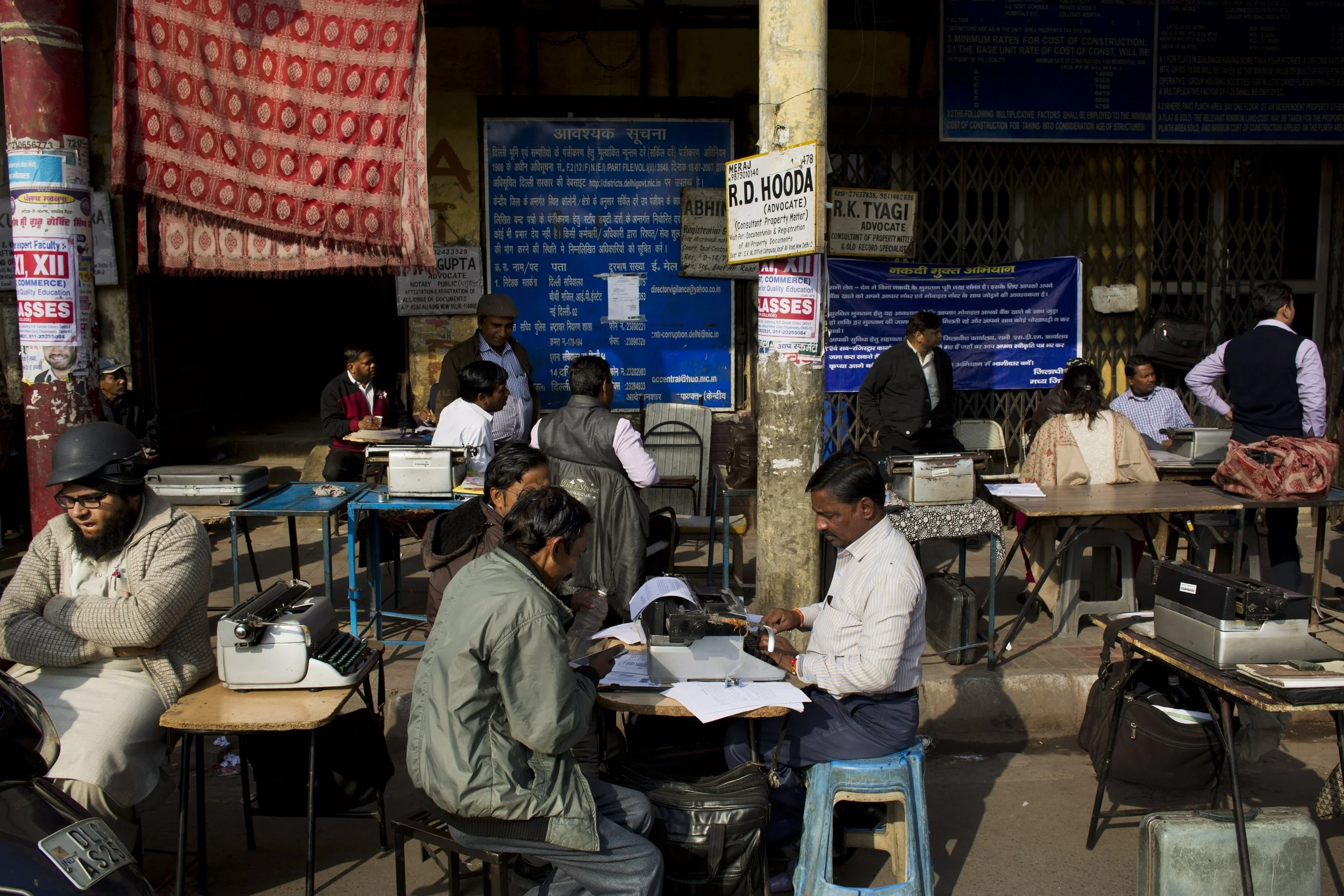 In this Jan. 18, 2017 photo, professional typists work on a roadside near Delhi's stock exchange market in New Delhi, India. India is one of the last places in the world where the typewriter continues to cling to life. This country has thousands of professional typists, most of them working outside the country's courts and government offices. But even in India, where stodgy government bureaucracies have helped the typewriter survive, its twilight is at hand. (AP Photo/Bernat Armangue)