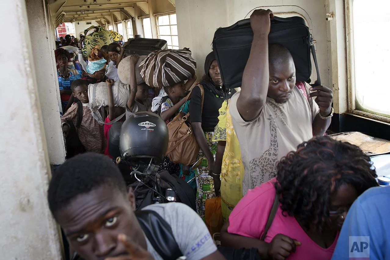 People wait to disembark from a ferry arriving at the port in Banjul, Gambia, Saturday Jan. 21, 2017, as life slowly returns to the Gambian capital. Gambia's defeated leader Yahya Jammeh announced early Saturday he has decided to relinquish power, after hours of last-ditch talks with regional leaders and the threat by a regional military force to make him leave. (AP Photo/Jerome Delay)