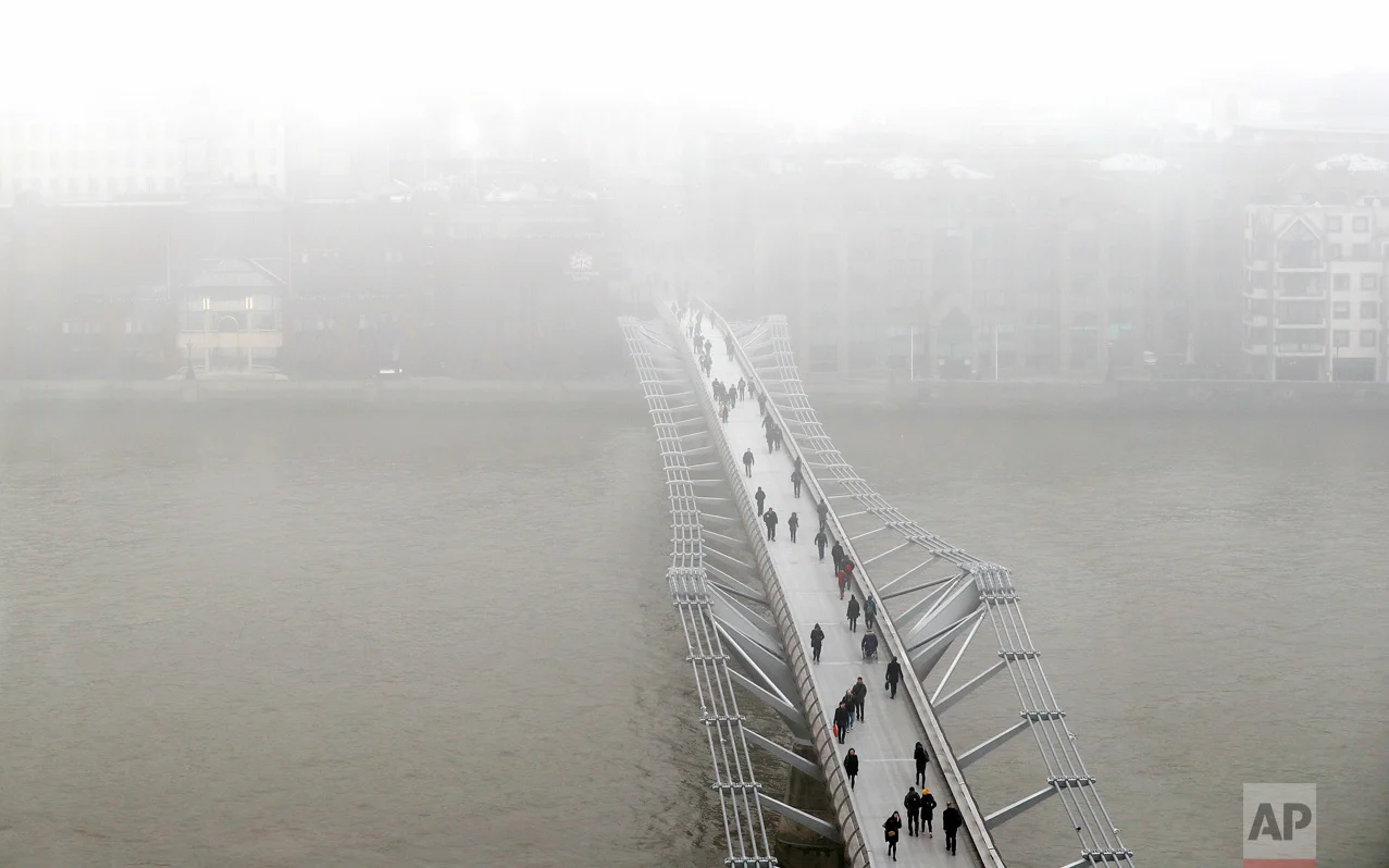 Pedestrians walk over the Millennium Bridge as fog shrouds St Paul's Cathedral in London, Monday, Jan. 23, 2017. Freezing fog covered the capital on Monday as cold weather conditions continued. (AP Photo/Kirsty Wigglesworth)
