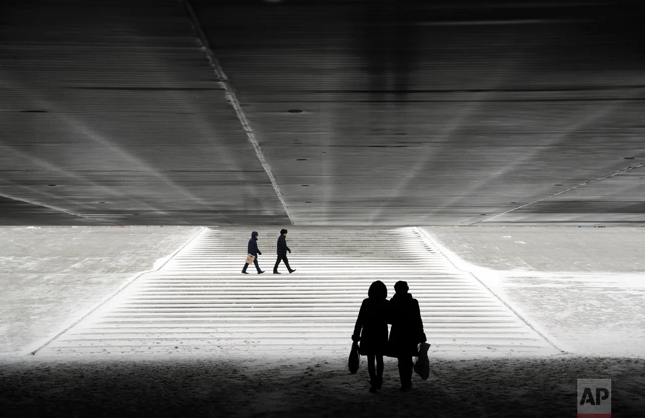 People walk through an underpass in Astana, Kazakhstan, Wednesday, Jan. 25, 2017. The Kazakh capital was hit by a heavy gale and a snowfall with a temperature of - 6 C (F 21). (AP Photo/Sergei Grits)