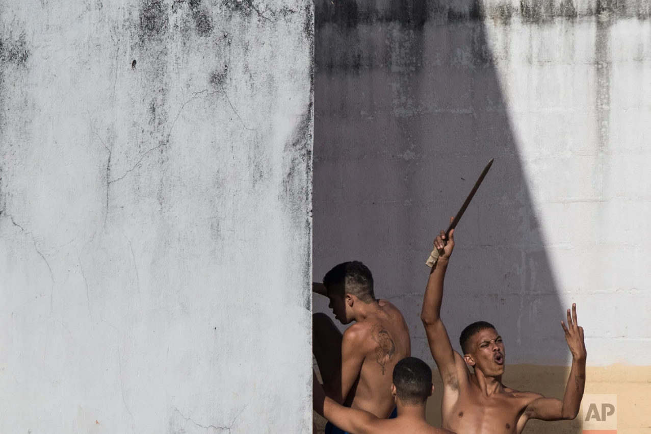 An inmate holds up a makeshift knife moments after police left the prison in the Alcacuz prison in Nisia Floresta, near Natal, Brazil, on Tuesday, Jan. 24, 2017. Military police had entered the facility in northeastern Brazil where a temporary wall separating two rival gangs is being built, after a week of chaos and fighting between rival gangs that left dozens of inmates dead. (AP Photo/Felipe Dana)