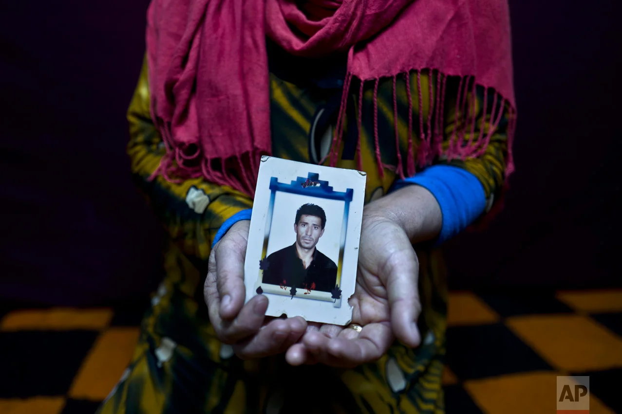 In this Tuesday, Jan. 24, 2017 photo, Heven Daood, 39, a Syrian refugee from Tell-Tawil in al-Hasaka, shows a photograph of her husband Reiad, 45, at her shelter in Ritsona refugee camp, Greece. "I have this photograph with me for the last 10 years, it is a very precious picture, my husband used to travel a lot for work, and this image always remained close to my heart." Heven said. (AP Photo/Muhammed Muheisen)