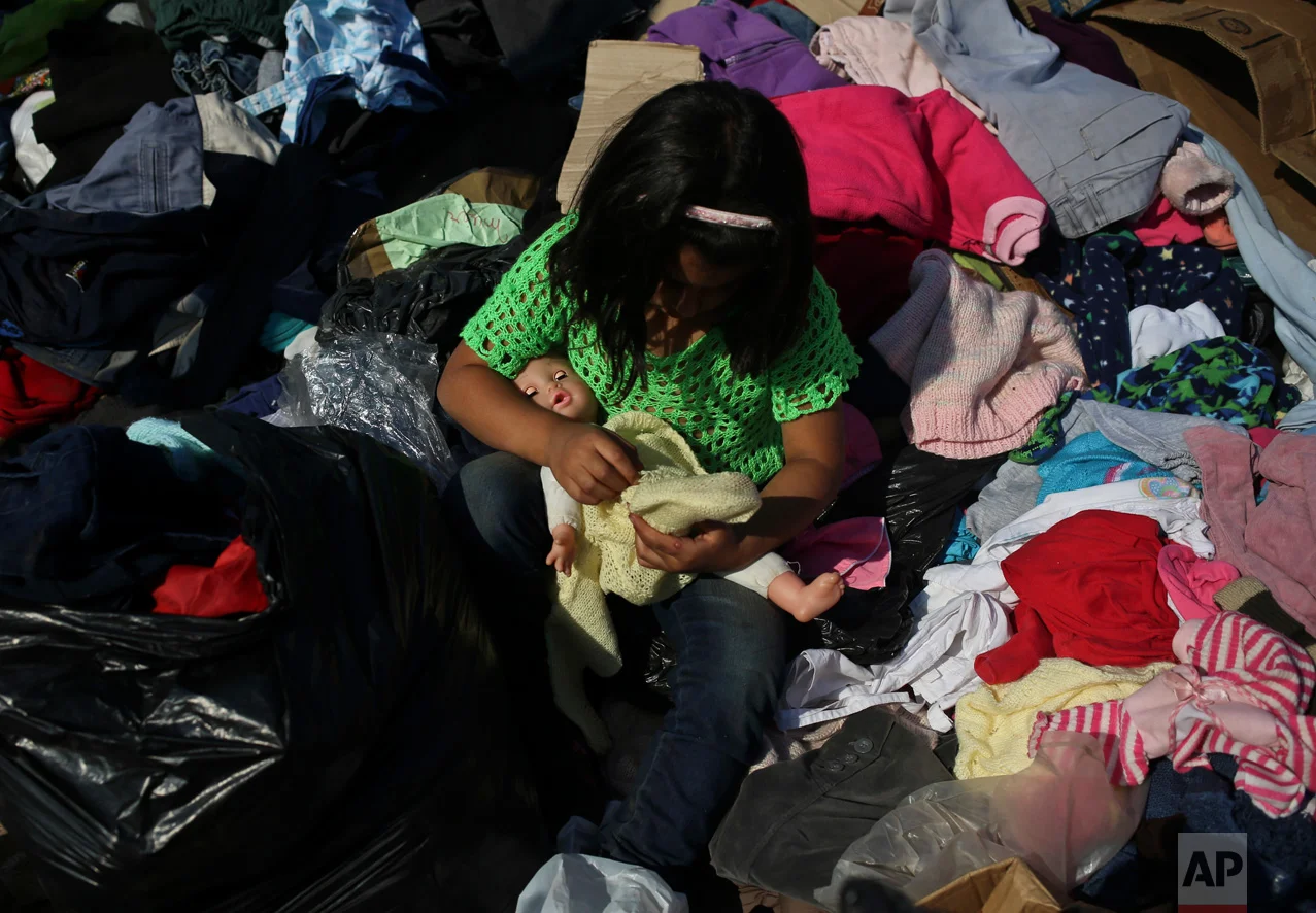 Jenny Tapia dresses her doll with clothes donated to victims of Chile's raging wildfires, in the community of Santa Olga, Chile, Tuesday, Jan. 31, 2017. Flames from one of the country's worst wildfires completely consumed the town of Santa Olga. (AP Photo/Esteban Felix)