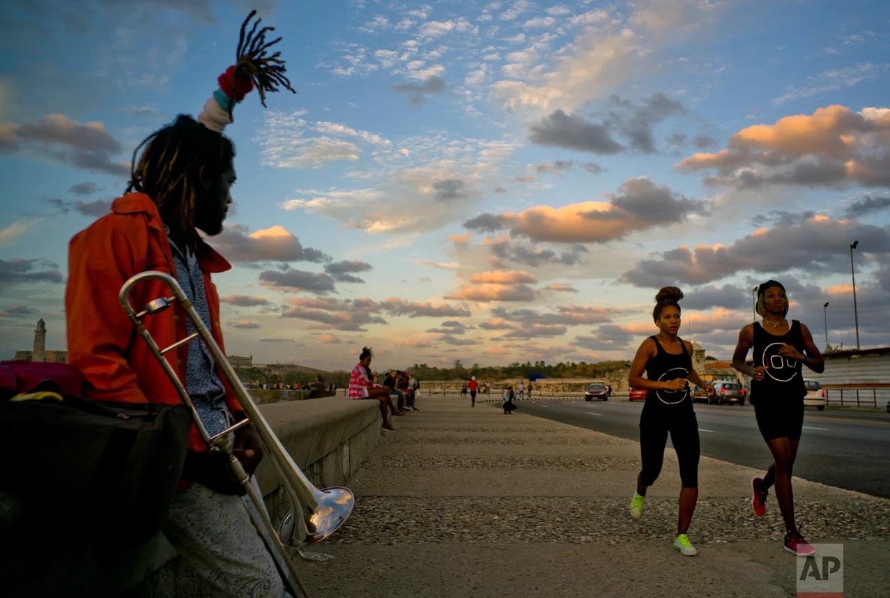 In this Jan. 30, 2017 photo, boxers Idamelys Moreno, second right, and Legnis Cala, right, run along Havana's Malecon, in Cuba. Moreno and Cala are part of a group of up-and-coming female boxers on the island who want government support to form Cuba's first female boxing team and help dispel a decades-old belief once summed up by a former top coach: "Cuban women are meant to show the beauty of their face, not receive punches." (AP Photo/Ramon Espinosa)