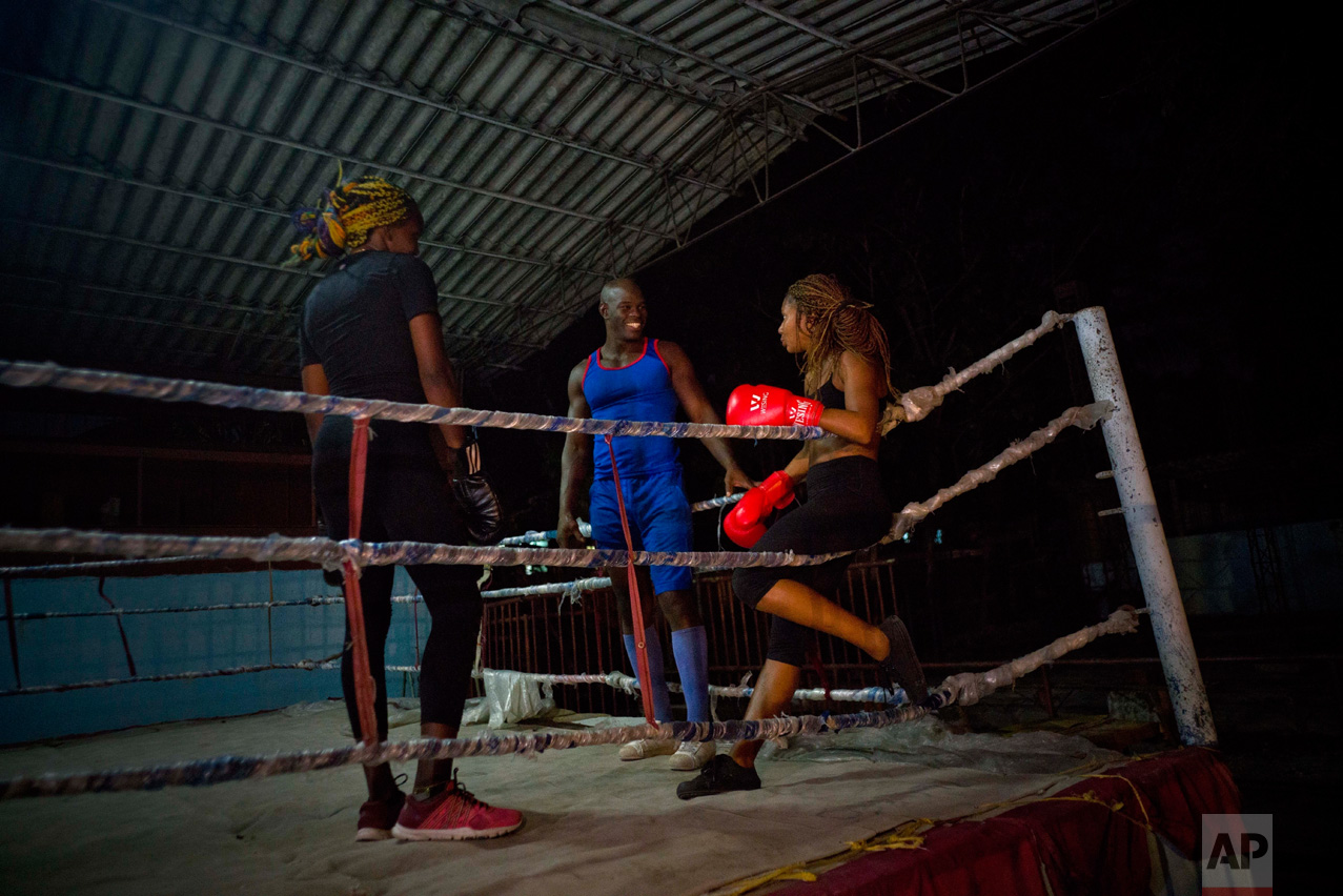In this Jan. 24, 2017 photo, Olympic silver medalist Emilio Correa Jr., center, instructs Idamelys Moreno, right, and Legnis Cala, at a sports center in Havana, Cuba. Once when the women were kicked out a of boxing gym, Correa Jr. stepped in to help some of them find another gym while they push top Cuban officials to support female boxing. (AP Photo/Ramon Espinosa)