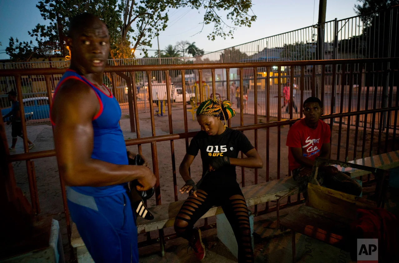 In this Jan. 24, 2017 photo, Olympic silver medalist Emilio Correa Jr., left, mentors female boxer Legnis Cala, center, at a sports center in Havana, Cuba. "They can bring more glory to the Cuban sport," Correa said. "They are diamonds in the rough. The motor skills, the explosive nature and the energy of Cuban boxers are also present in these women." (AP Photo/Ramon Espinosa)