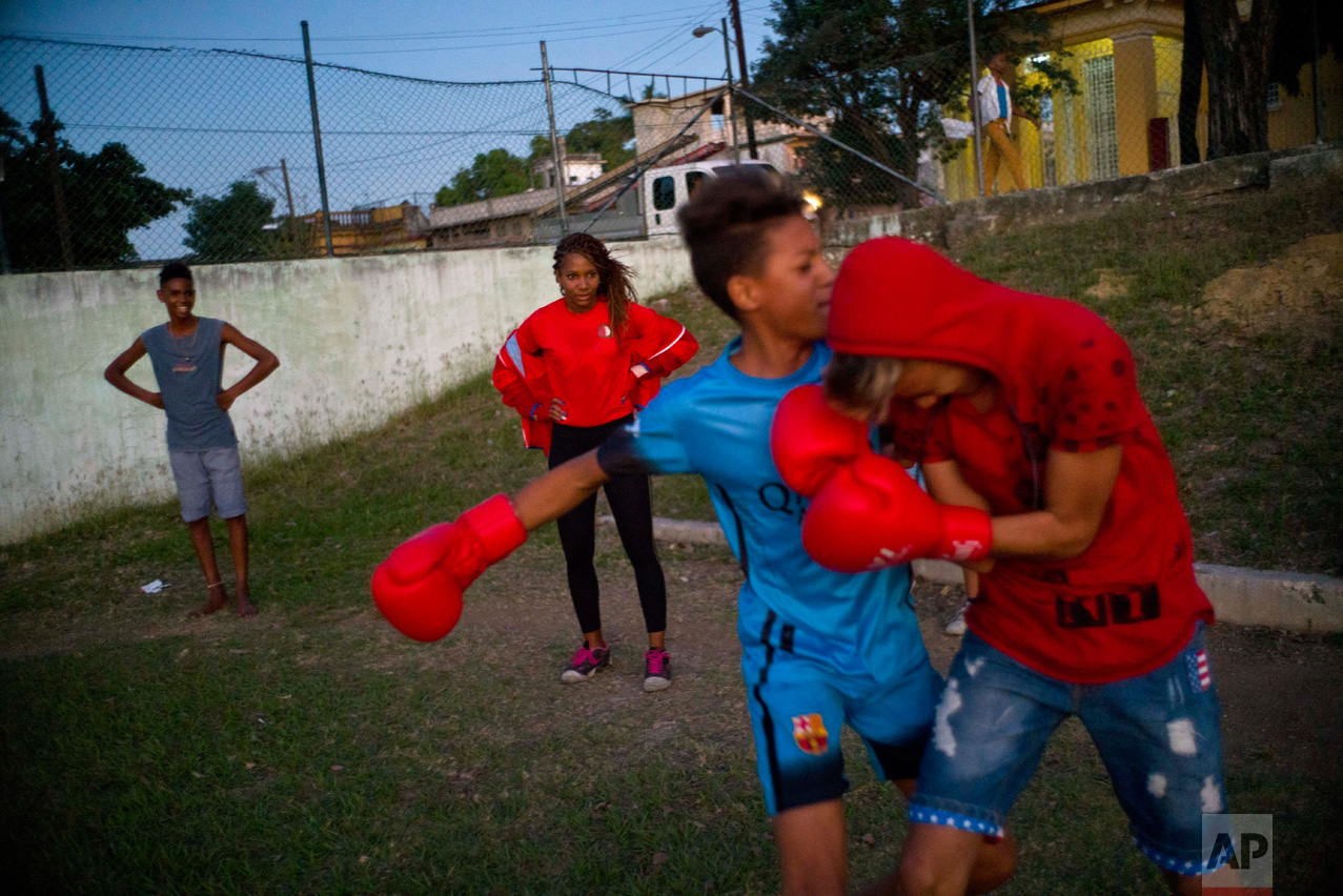 In this Jan. 19, 2017 photo, boxer Idamelys Moreno, center back, looks at children playing around, at a sports center in Havana, Cuba. Boxing has long been an athletic engine for Cuba, which has won 72 Olympic medals in that category but women are not allowed to box. (AP Photo/Ramon Espinosa)