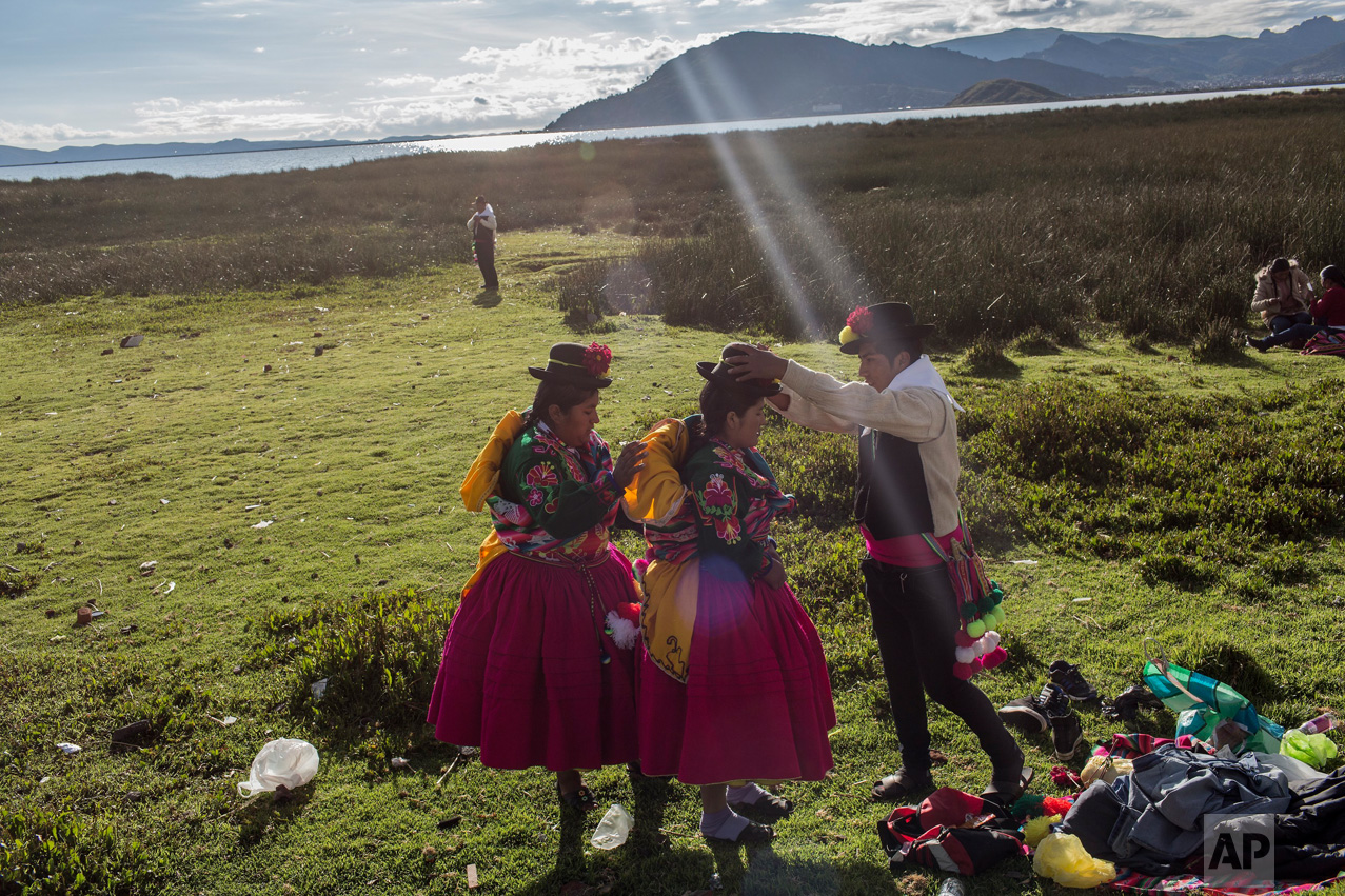 In this Jan. 29, 2017 photo, dancers get ready near Lake Titicaca prior to their performance at Virgin of Candelaria celebrations in Puno, Peru. The festivities start this week. (AP Photo/Rodrigo Abd)