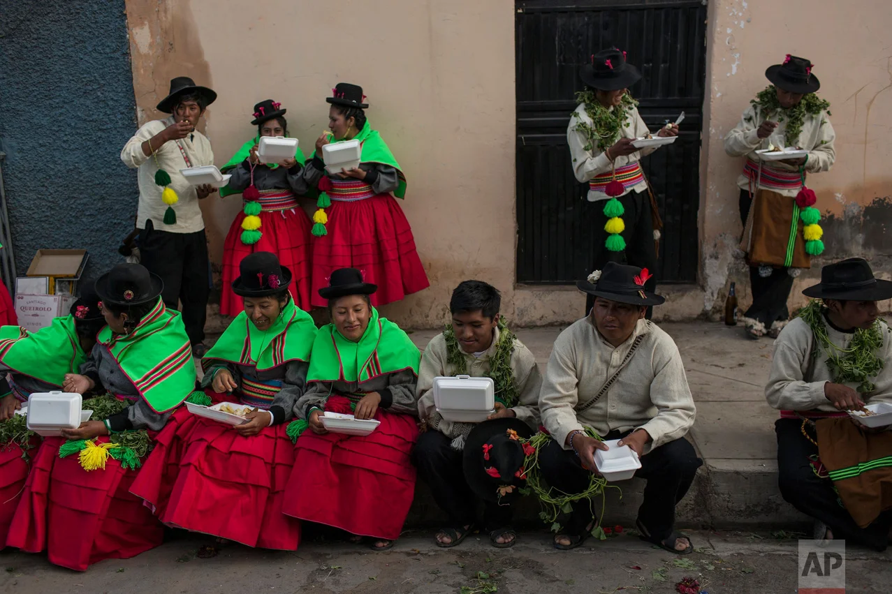 In this Jan. 29, 2017 photo, dancers eat lunch after performing during Virgin of Candelaria celebrations in Puno, Peru. In addition to adults, young children dance with their families in groups of as many as 400 people, including musicians who play …