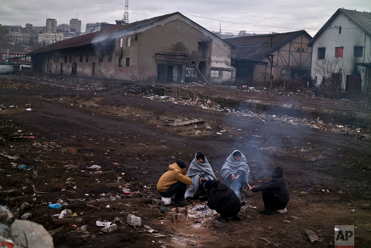  Migrants gather around a fire to warm themselves from the morning cold outside an abandoned warehouse where they are taking refuge, in Belgrade, Serbia, Thursday, Feb. 2, 2017. &nbsp;(AP Photo/Muhammed Muheisen) 