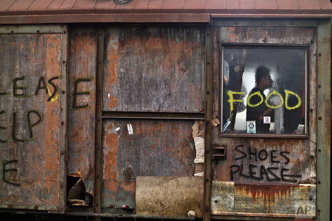 An Afghan refugee youth gets dressed in an old train carriage where he and other migrants took refuge in Belgrade, Serbia, Thursday, Feb. 2, 2017. (AP Photo/Muhammed Muheisen)