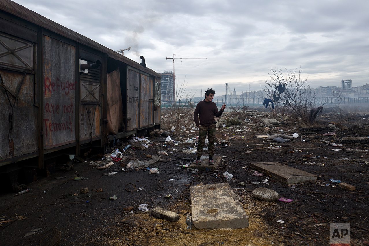  An Afghan refugee speaks on a mobile phone outside an old train carriage where he and other migrants took refuge in Belgrade, Serbia, Thursday, Feb. 2, 2017. &nbsp;(AP Photo/Muhammed Muheisen) 