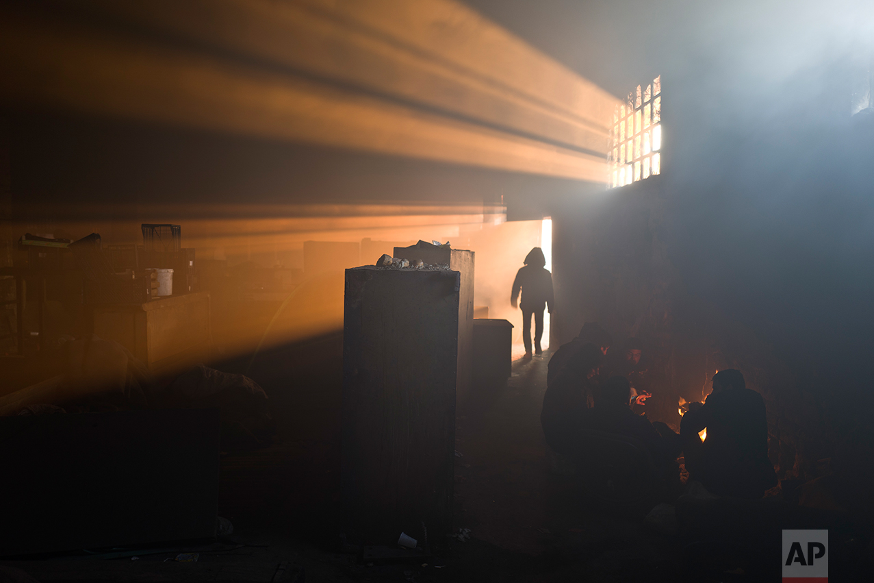  A group of migrants warm themselves by a fire in an abandoned warehouse in Belgrade, Serbia, Monday, Jan. 30, 2017. (AP Photo/Muhammed Muheisen) 