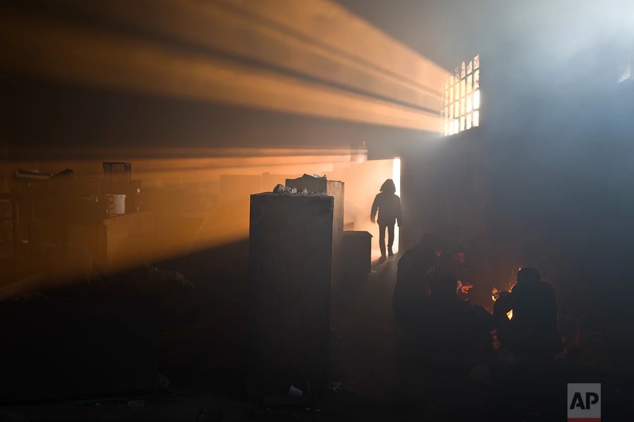 A group of migrants warm themselves by a fire in an abandoned warehouse in Belgrade, Serbia, Monday, Jan. 30, 2017. (AP Photo/Muhammed Muheisen)