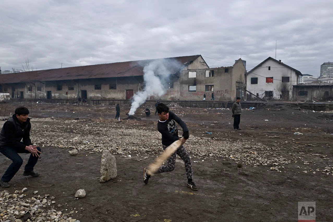 Migrants play cricket outside an abandoned warehouse where they are taking refuge in Belgrade, Serbia, Thursday, Feb. 2, 2017. (AP Photo/Muhammed Muheisen)