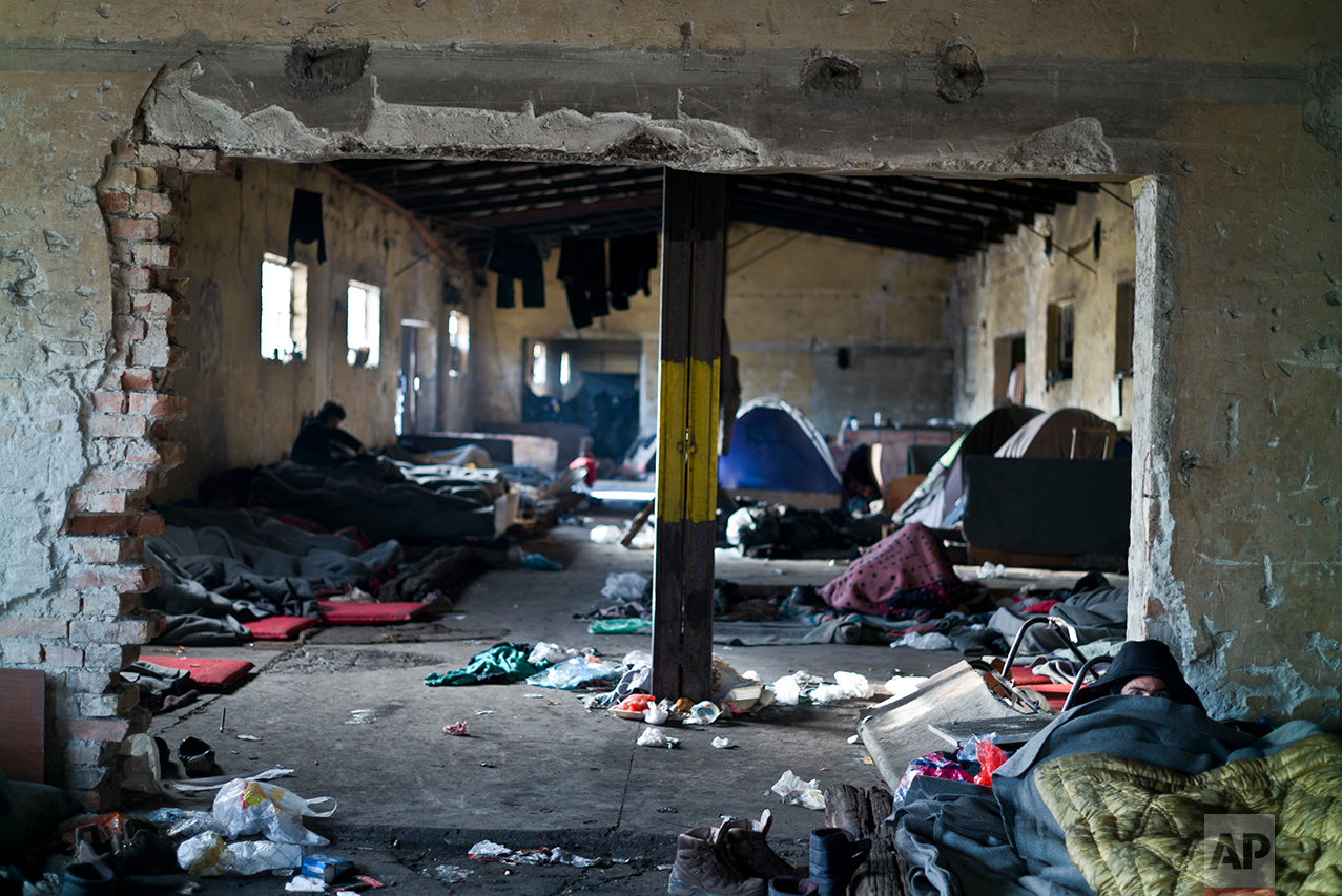  An Afghan refugee, right, lies on the ground of an abandoned warehouse where he and other migrants took refuge in Belgrade, Serbia, Tuesday, Jan. 31, 2017. &nbsp;(AP Photo/Muhammed Muheisen) 