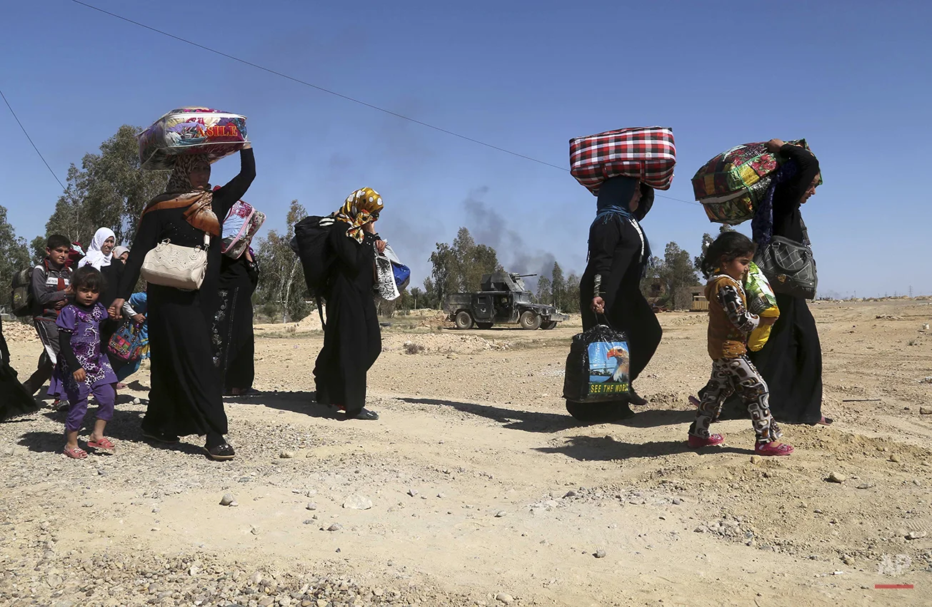 People flee their homes during clashes between Iraqi security forces and Islamic State group in Hit, 85 miles (140 kilometers) west of Baghdad, Iraq, Monday, April 4, 2016. Families, many with small children and elderly relatives say they walked for…