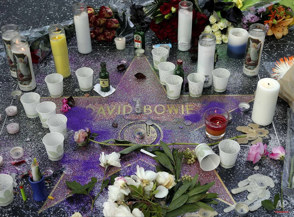 A makeshift memorial surrounds David Bowie’s star on the Hollywood Walk of Fame in Los Angeles, Monday, Jan. 11, 2016. Bowie, the other-worldly musician who broke pop and rock boundaries with his creative musicianship, nonconformity, striking visuals and a genre-spanning persona he christened Ziggy Stardust, died of cancer Sunday. He was 69 and had just released a new album. (AP Photo/Nick Ut)