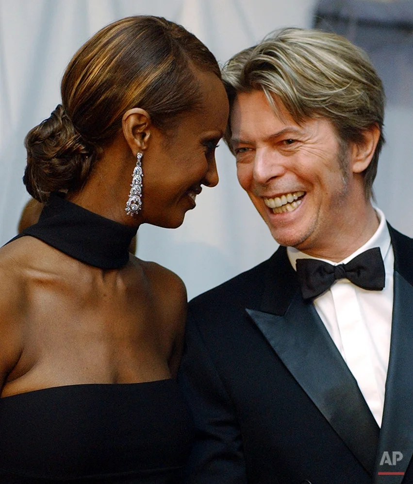 In this June 3, 2002, photo, Iman, left, and her husband, singer David Bowie arrive at the Council of Fashion Designers of America Fashion Awards in New York. (AP Photo/Suzanne Plunkett)