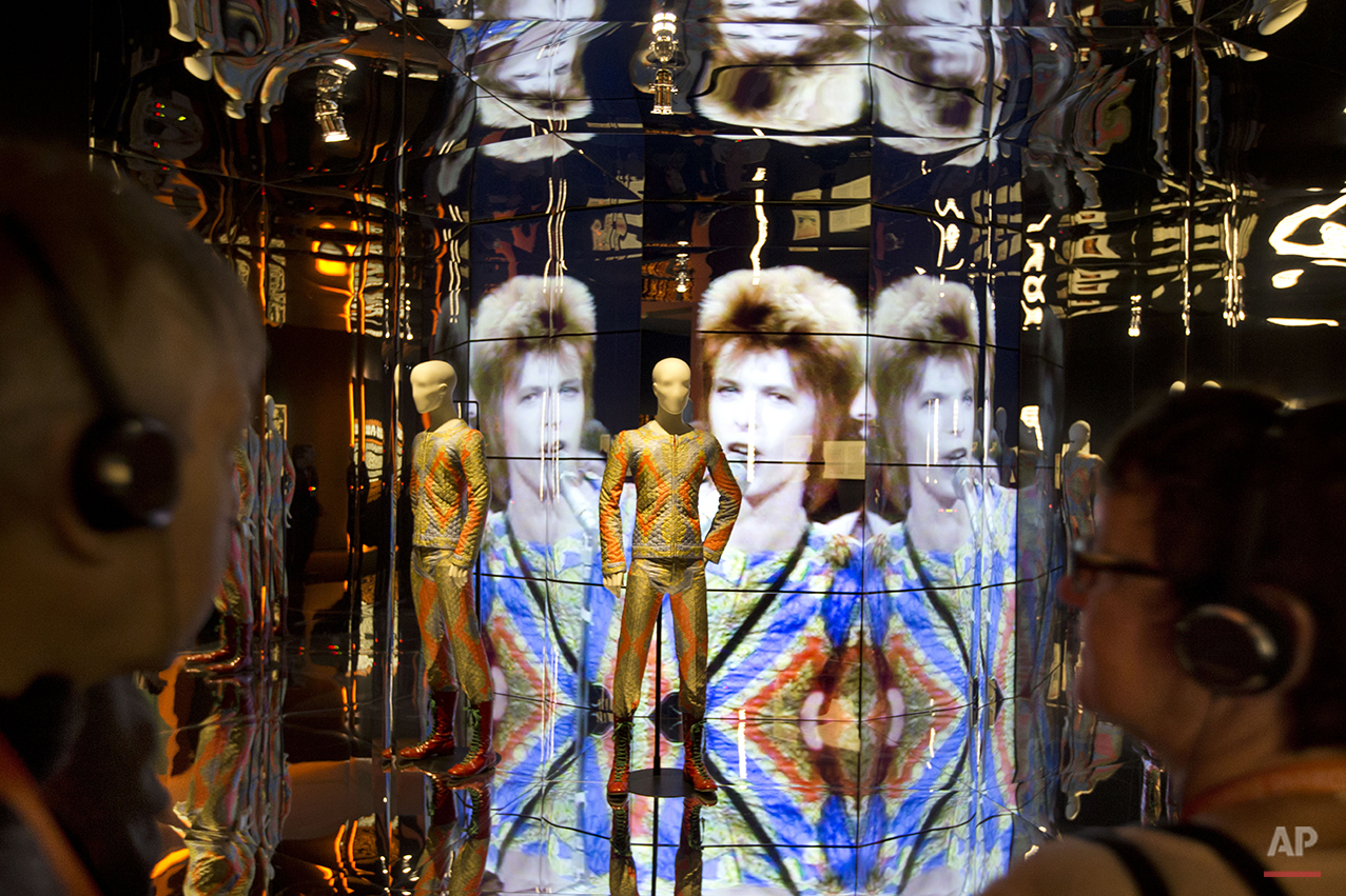 Visitors take an audio tour at the Groninger Museum which hosts the "DAVID BOWIE is' exhibit, in Groningen, northern Netherlands, Monday, Jan. 11, 2016. The museum is normally closed on Mondays but opened its doors to allow people to sign a book of condolences for the deceased popstar and visit the Bowie exhibit which runs till March 13, 2016. (AP Photo/Peter Dejong)