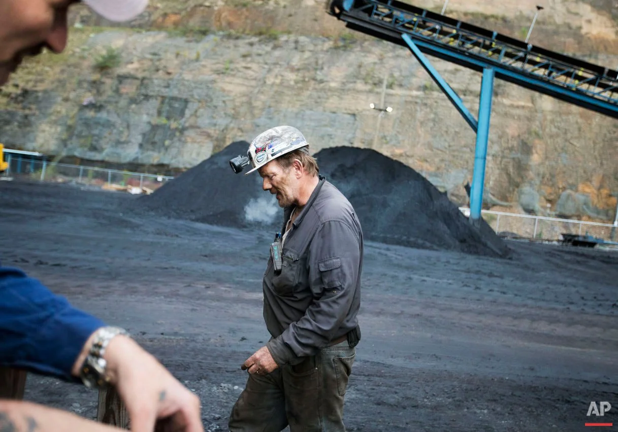 Foreman John Dillon, a coal miner of 39 years, walks past piles of coal at the Sewell "R" coal mine Tuesday, Oct. 6, 2015, in Yukon, W.Va. In the U.S., where natural gas has become a cheaper alternative to coal to generate electricity, miners are facing an especially difficult market: Four major U.S. coal companies have filed for bankruptcy protection in the last 18 months. (AP Photo/David Goldman)