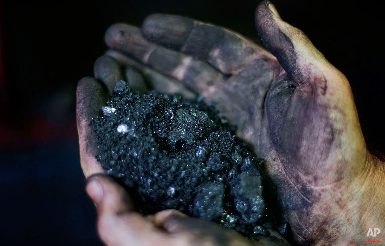 Superintendent Jackie Ratliff, a coal miner of 25 years, holds coal running through a processing plant Tuesday, Oct. 6, 2015, in Welch, W.Va. Central Appalachia's struggle is familiar to many rural regions across the U.S., where middle-class jobs are disappearing or gone and young people have no other choice than to leave to find opportunity. But the problems are amplified in coal country, where these difficult economic and social conditions have gripped the region for decades and where there is hardly any flat land to build anything. (AP Photo/David Goldman)