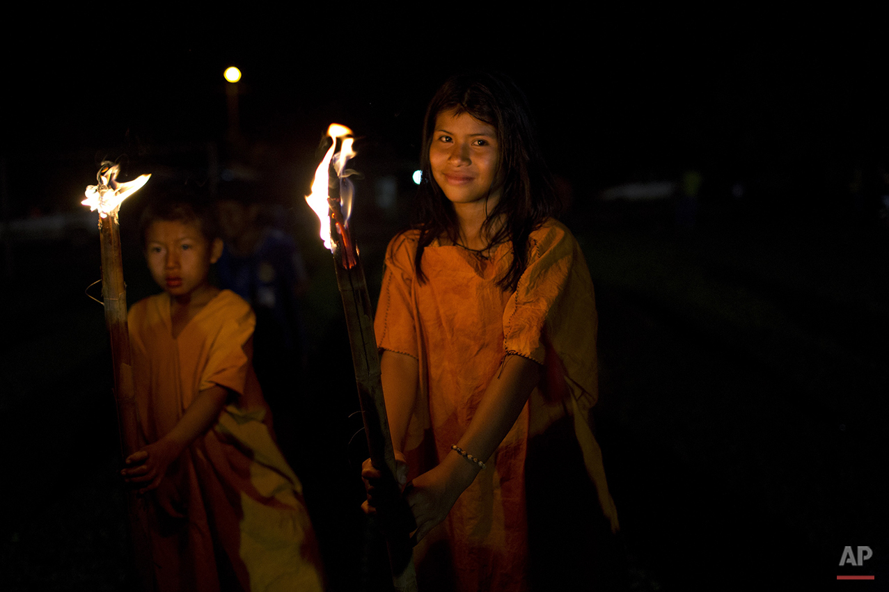  In this June 23, 2015 photo, Ashaninka Indian school children parade with torches during festivities celebrating the 44th anniversary of their village, in Otari Nativo, Pichari, Peru. The village is located in a valley near the Apurimac, Ene and Man