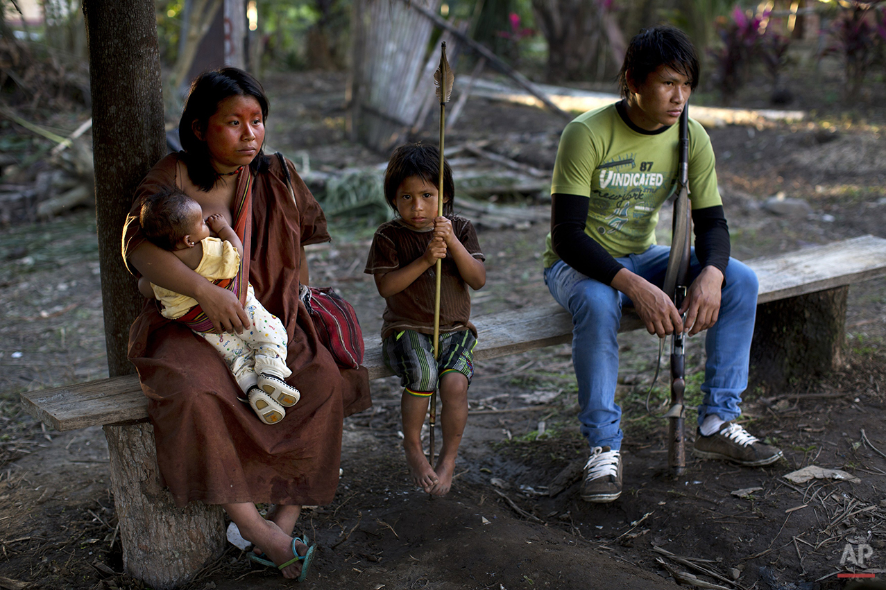  In this June 23, 2015 photo, a couple gather with their sons in Otari Nativo village, Pichari, Peru. The man holds a rifle. (AP Photo/Rodrigo Abd) 