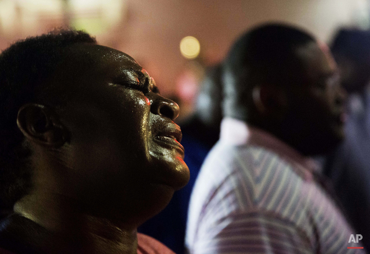 Lisa Doctor joins a prayer circle down the street from the Emanuel AME Church following a mass shooting that claimed the lives of its pastor and eight others Wednesday, June 17, 2015, in Charleston, S.C. (AP Photo/David Goldman)