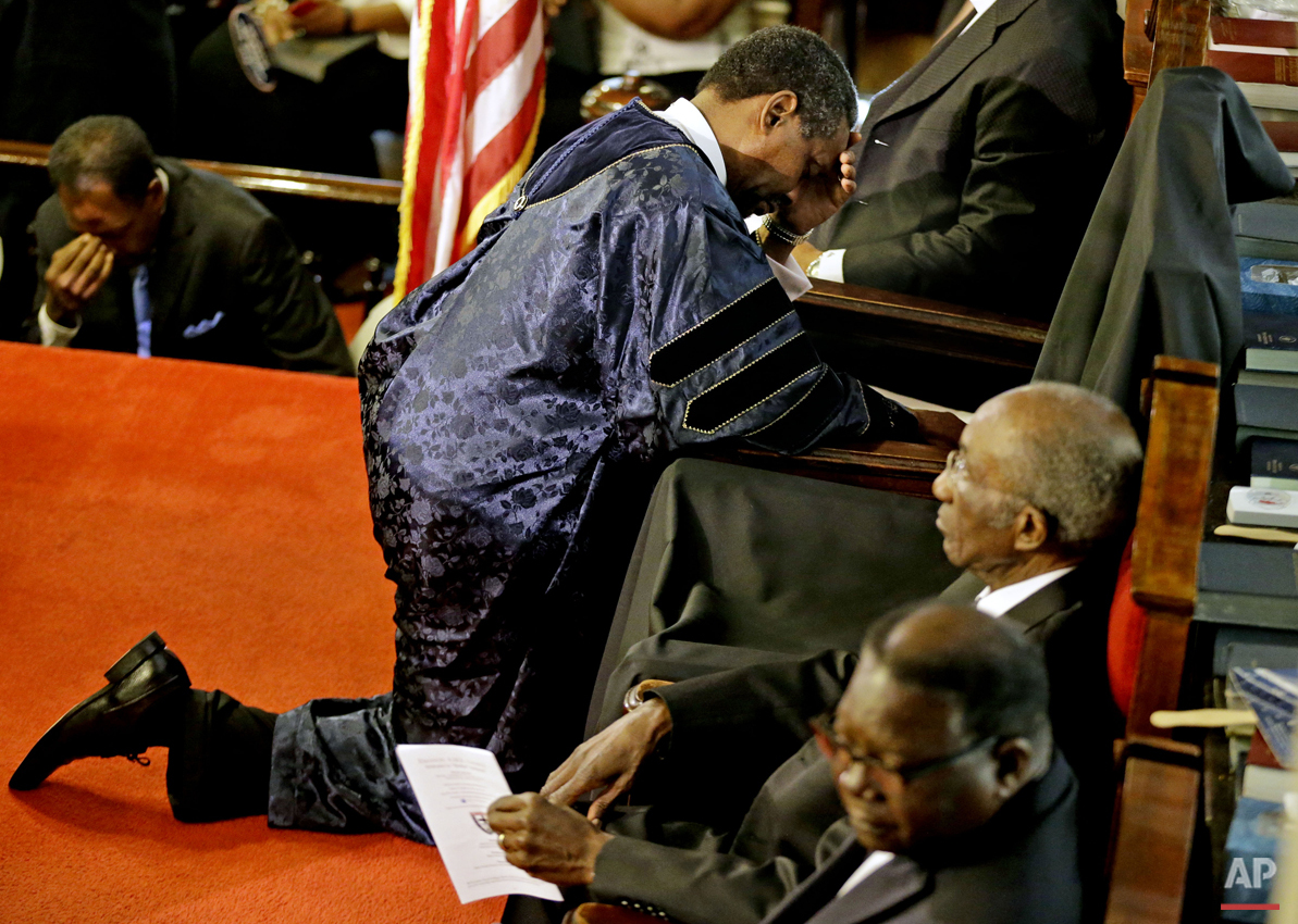 Rev. Norvel Goff prays at the empty seat of the Rev. Clementa Pinckney during the first service at the Emanuel A.M.E. Church Sunday, June 21, 2015, in Charleston, S.C., since a mass shooting claimed the lives of Pinckney and eight others four days earlier. (AP Photo/David Goldman, Pool)