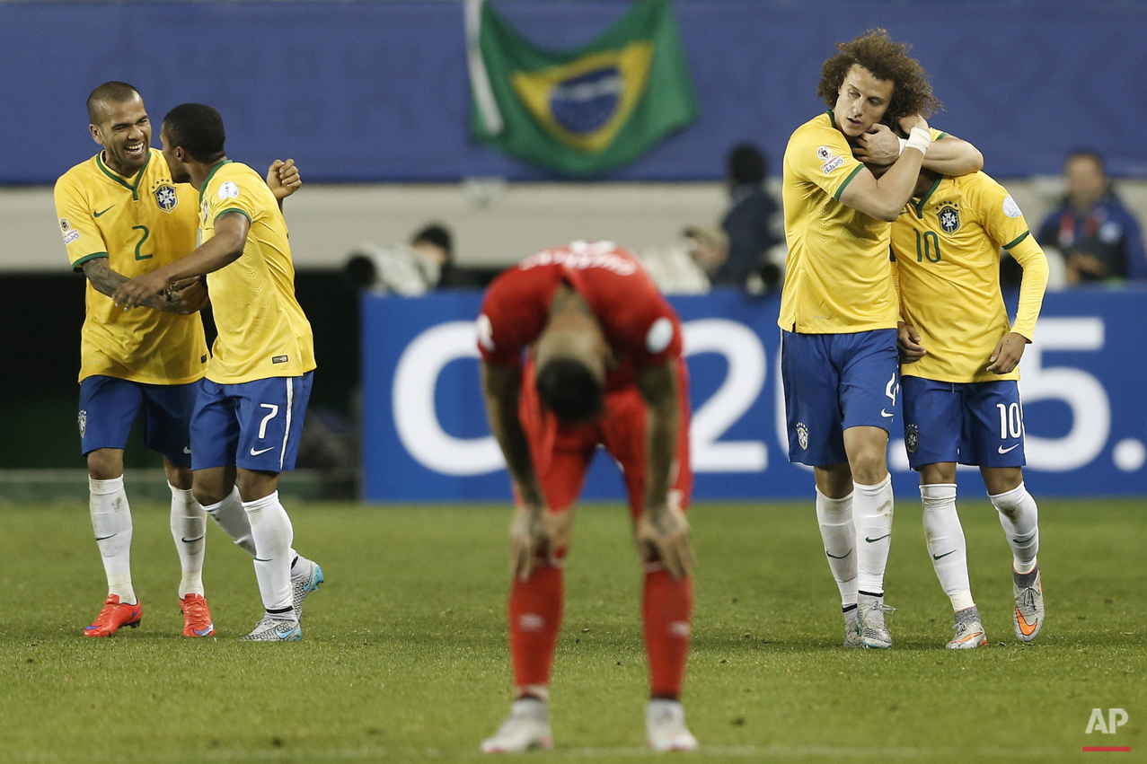 Brazil's Douglas Costa, second left, celebrates his goal against Peru with teammate Brazil's Dani Alves, left, as Brazil's David Luiz, second right, hugs Brazil's Neymar, right, during a Copa America Group C soccer match at the German Becker stadium in Temuco, Chile, Sunday, June 14, 2015. Brazil won the match 2-1. (AP Photo/Silvia Izquierdo)