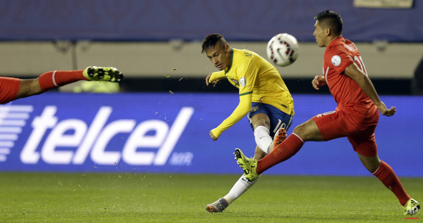 Brazil's Neymar kicks the ball through two Peruvian players during a Copa America Group C soccer match at the Bicentenario Germ·n Becker stadium in Temuco, Chile, Sunday, June 14, 2015. (AP Photo/Jorge Saenz)