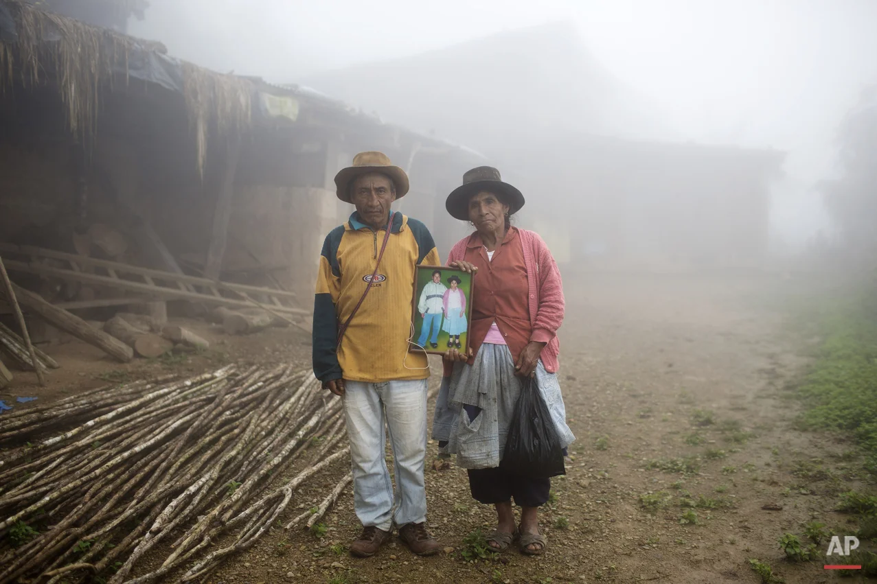  In this March 15, 2015 photo, Julio Galvez and his wife Rufina Miguel, pose for a picture holding a portrait of their late son Yuri Galvez, outside their home, in La Mar, province of Ayacucho, Peru. The 25-year-old university student had gotten his 