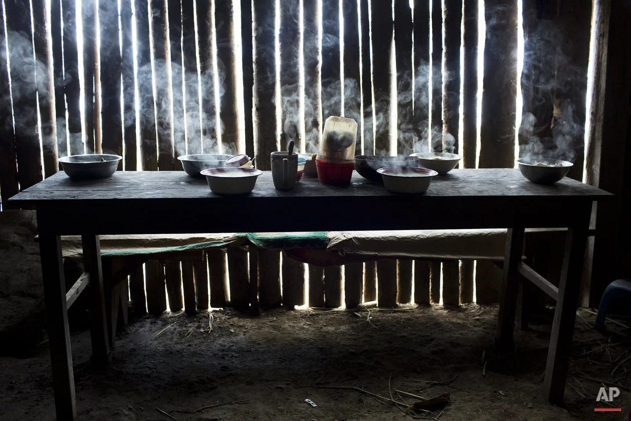 In this March 15, 2015 photo, steaming bowls of chicken soup on a table set for a special meal marking the second death anniversary of cocaine backpacker Yuri Galvez, in La Mar, province of Ayacucho, Peru. Galvez, 25, was found dead two years to the date, while taking part in a cocaine smuggling trip with other backpackers. (AP Photo/Rodrigo Abd)
