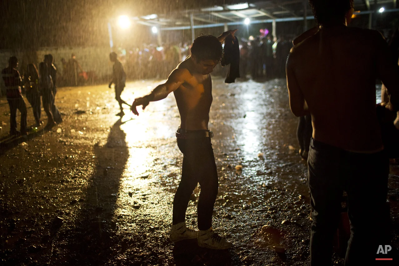 In this March 16, 2015 photo, a young man dances under a heavy rain during Peruvian Huayno singer Ely Corazon's concert, in La Mar, province of Ayacucho, Peru. The average cocaine backpacker or mochilero is surprisingly normal, says sociologist Laura Barrenechea. Few are troublemakers or social misfits. Typically, they are recruited by relatives and friends - often at festivities where liquor flows. They tend not to tell their parents, who nearly always disapprove. (AP Photo/Rodrigo Abd)