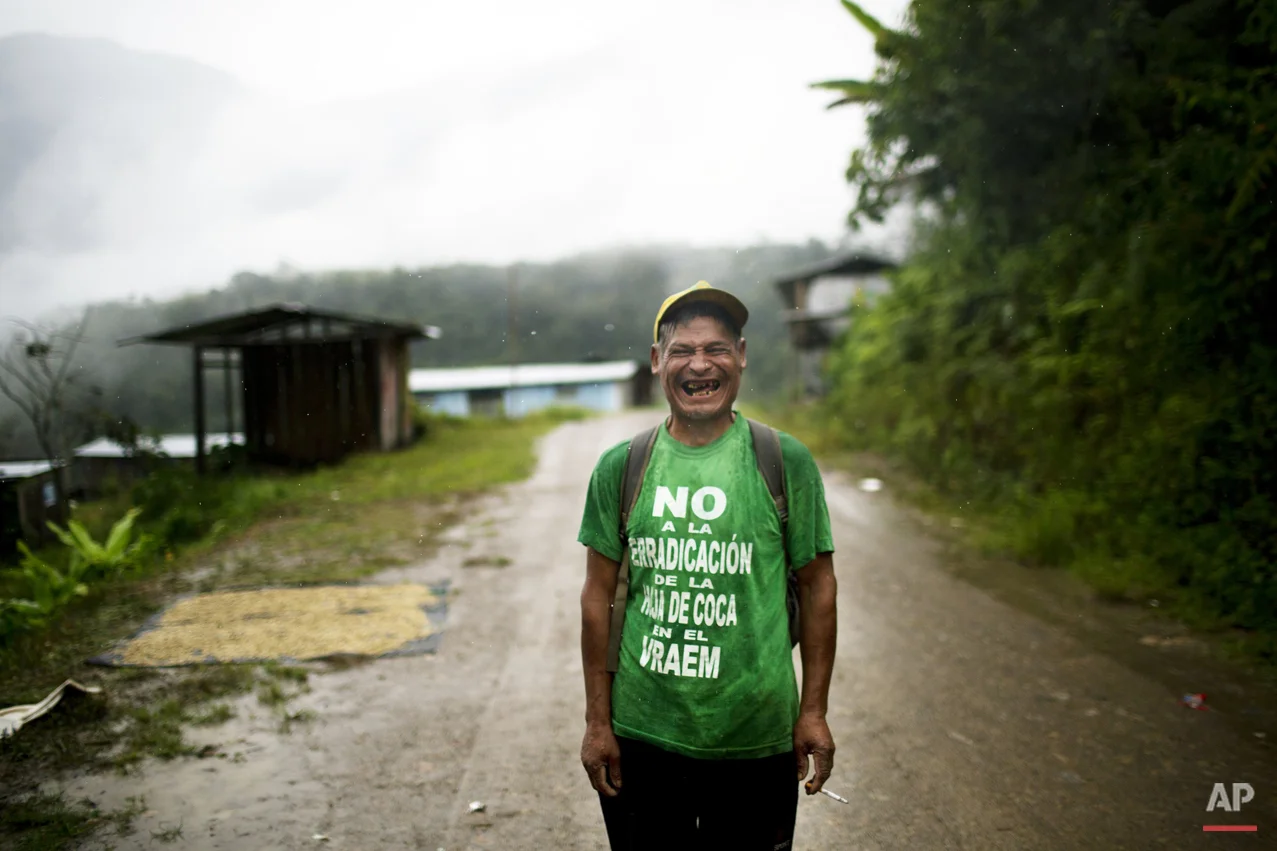 In this March 15, 2015 photo, Fortunato Farfan, laughs while posing for the picture in La Mar, province of Ayacucho, Peru. Fortunato's is wearing a T-shirt with a phrase that reads in Spanish: "No to coca eradication in the Vraem". Not a single fully paved road rises out of the Apurimac, Ene and Mantauro river valley (VRAEM), from which cocaine also departs via small plane to neighboring Bolivia. (AP Photo/Rodrigo Abd)