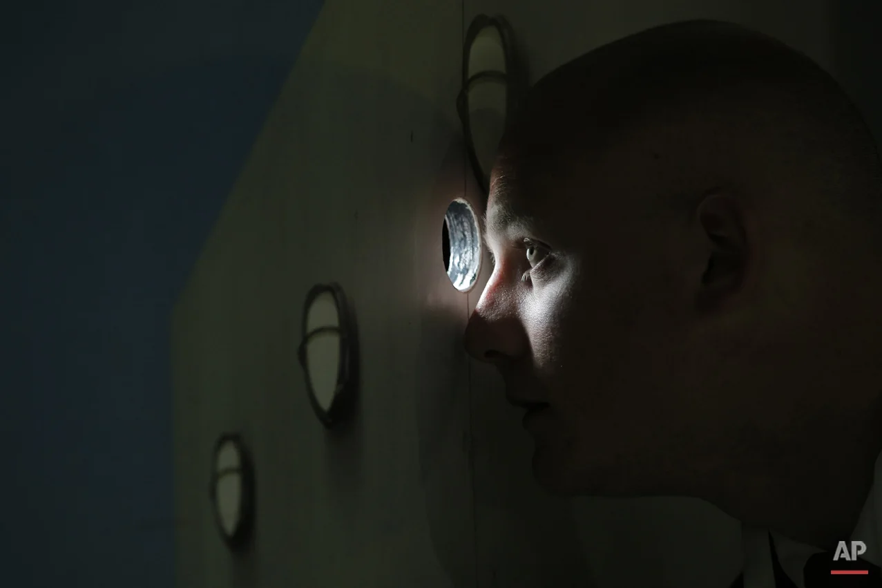  A security officer watches through a hole in the door for a break between games to let photographers into the stadium as Serbia's Ana Ivanovic plays in the first round match of the French Open tennis tournament against Yaroslava Shvedova of Kazakhst