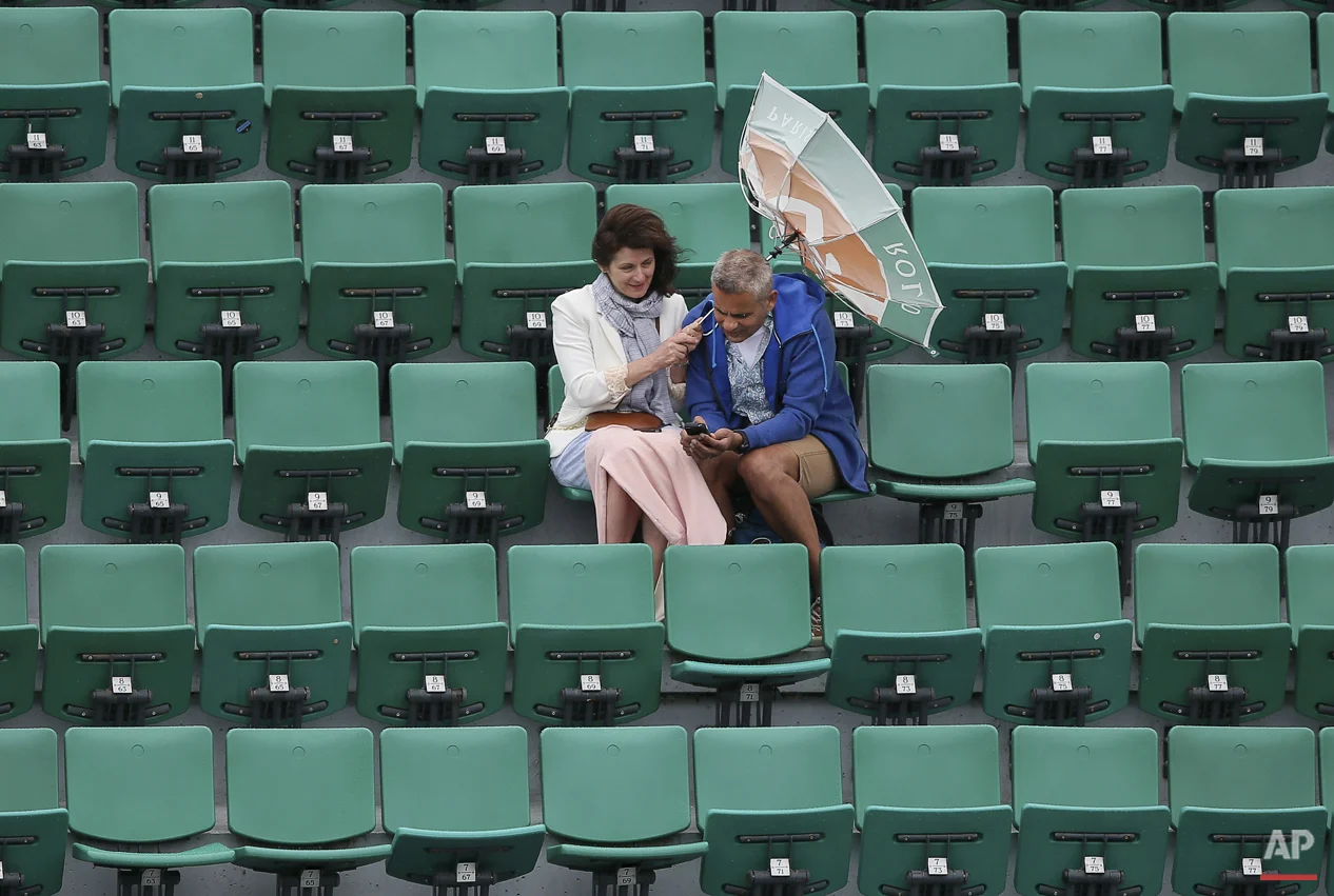  The wind pulls at the umbrella of a spectator as weather conditions suspended the fourth round match between France's Alize Cornet and Ukraine's Elina Svitolina at the French Open tennis tournament at Roland Garros stadium, in Paris, France, Sunday,