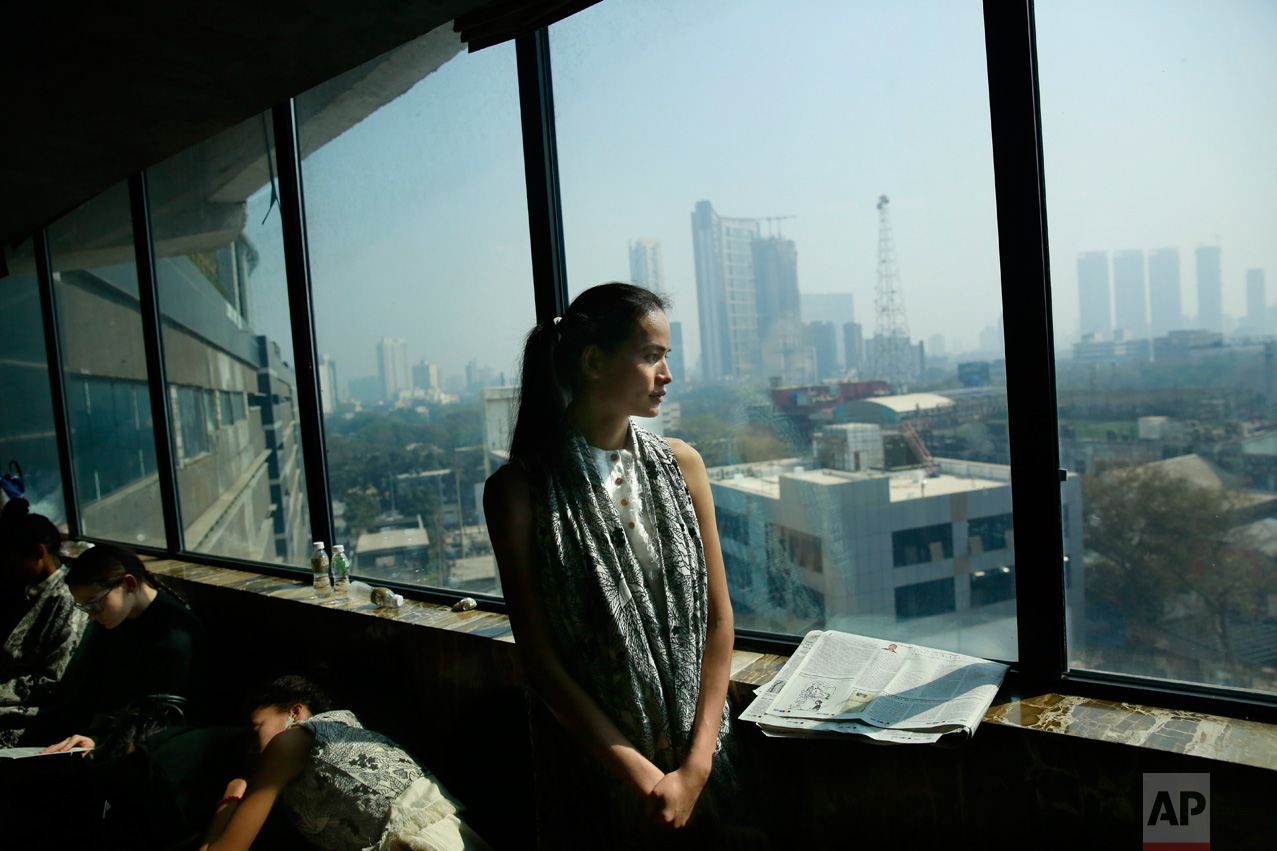 In this Jan 30, 2017 photo, Anjali Lama, a transgender model from Nepal, looks out of a window of a hotel during a trial event for Lakme Fashion week in Mumbai, India. Growing up as the fifth son in a poor farming family in rural Nepal the dream to be a fashion model came late in life. First came a long, painful struggle to accept that he felt deeply female. It was a chance encounter with a group of transgender women that turned Lama's life around by putting her in touch with the Blue Diamond Society, an advocacy group for Nepal's LGBT community. In 2005, she came out to her friends and family as a transgender woman. (AP Photo/Rafiq Maqbool)