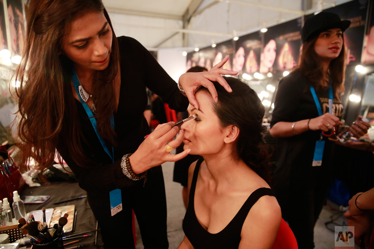 In this Feb. 1, 2017 photo, a makeup artist applies eye-shadow on Anjali Lama, a transgender model from Nepal, during Lakme Fashion week in Mumbai, India. Growing up as the fifth son in a poor farming family in rural Nepal the dream to be a fashion model came late in life. First came a long, painful struggle to accept that he felt deeply female. It was a chance encounter with a group of transgender women that turned Lama's life around by putting her in touch with the Blue Diamond Society, an advocacy group for Nepal's LGBT community. In 2005, she came out to her friends and family as a transgender woman. (AP Photo/Rafiq Maqbool)