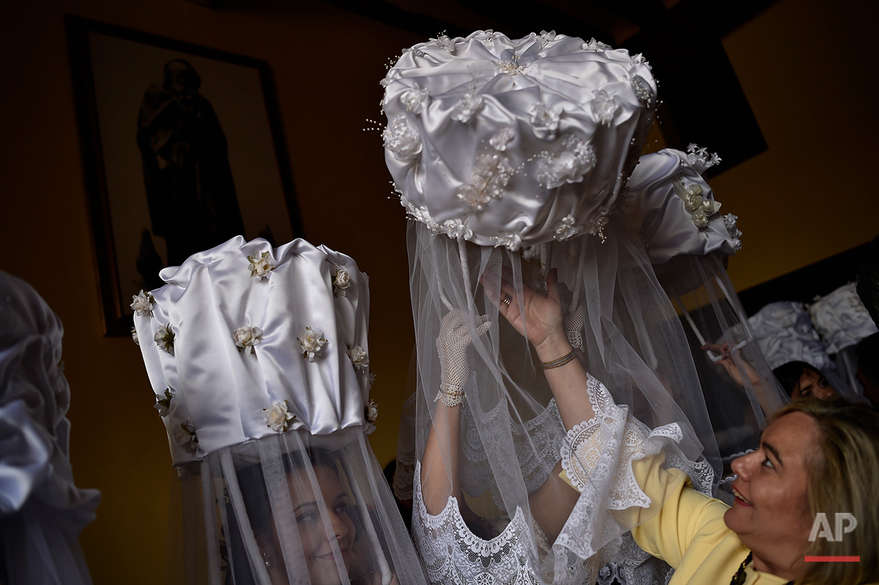  A participant of ''Bread Procession of the Saint'', is helped as she takes part in the ceremony in honor of Domingo de La Calzada Saint (1019-1109) in Santo Domingo de La Calzada, northern Spain, Wednesday, May 11, 2016.Every year during spring seas