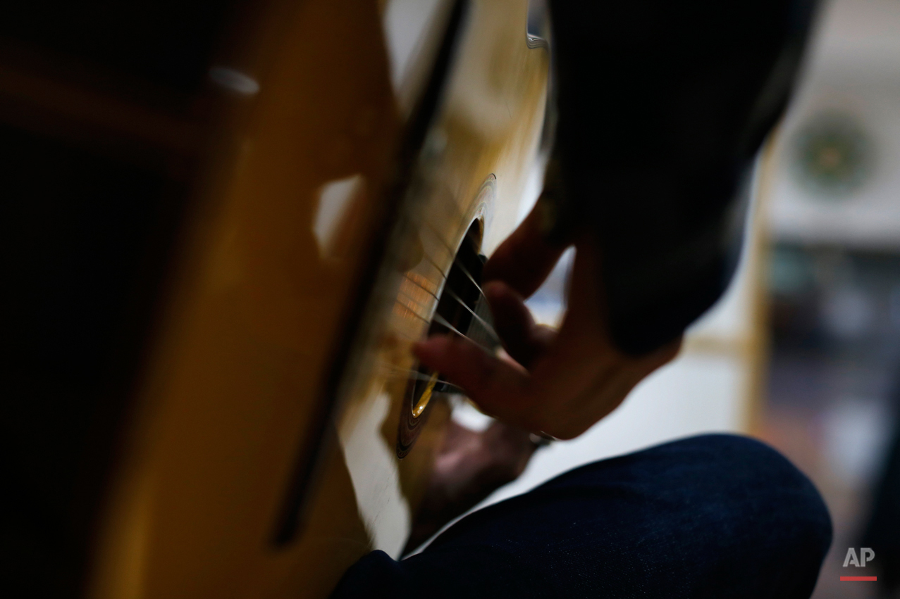  In this Wednesday, Nov. 11, 2015 photo, Spanish 'flamenco' artist Yoni Jimenez plays a guitar in a guitar workshop in Madrid. Spanish flamenco guitars are known for their beautiful shape, rich wood colors and full-bodied, crisp musical tones. (AP Ph